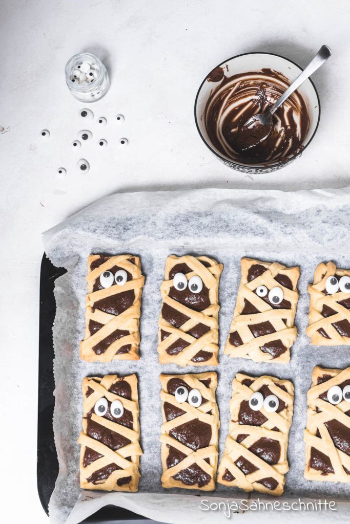 Ein einfaches Rezept für schaurig süße Mumien-Kekse Die Kekse sind das perfekte Fingerfood für Halloween-Partys und kommen nicht nur als Essen für Kinder gut an. Aber das Beste, die Mumien-Kekse für Halloween schmecken mega lecker. #halloweenparty #mumienkekse #sonjasahneschnitte #halloween