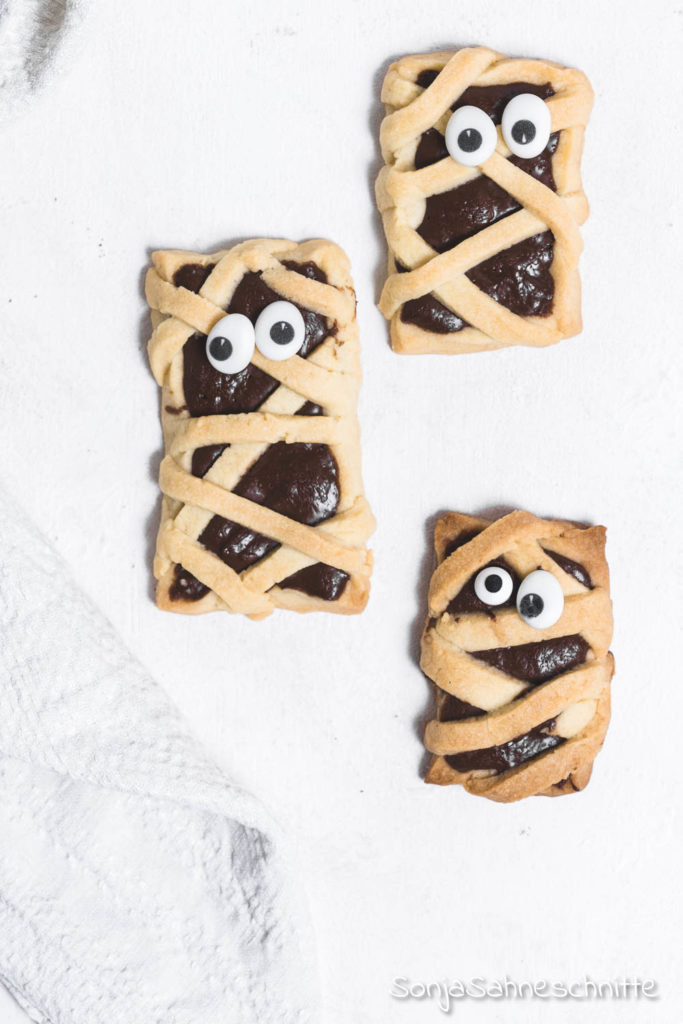 Ein einfaches Rezept für schaurig süße Mumien-Kekse Die Kekse sind das perfekte Fingerfood für Halloween-Partys und kommen nicht nur als Essen für Kinder gut an. Aber das Beste, die Mumien-Kekse für Halloween schmecken mega lecker. #halloweenparty #mumienkekse #sonjasahneschnitte #halloween